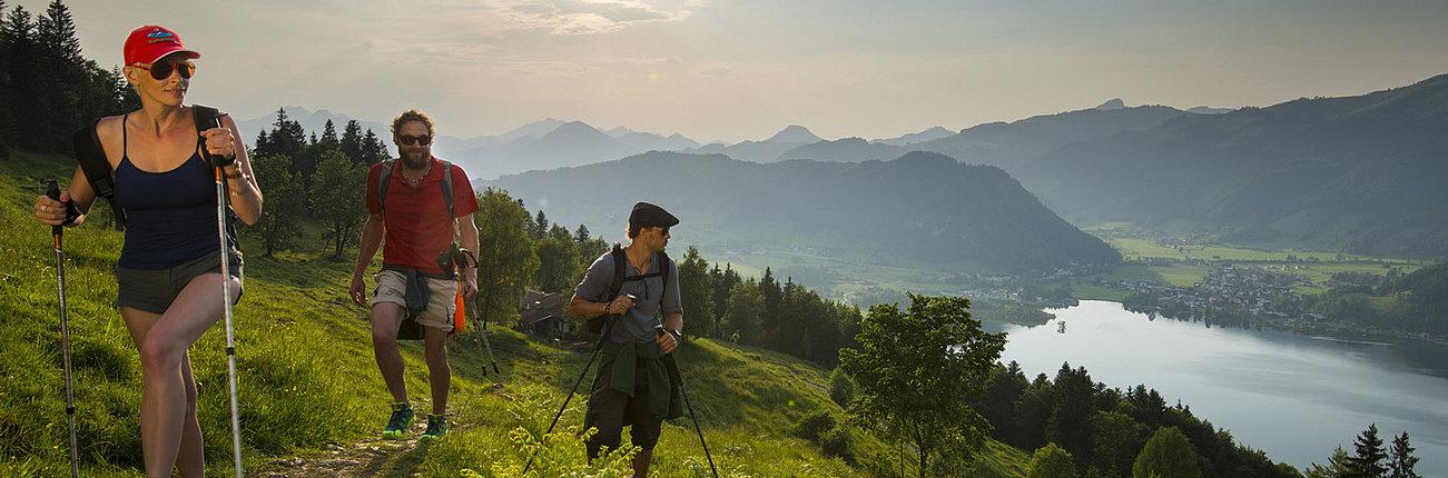 Group of three people hiking while enjoying the views to Walchsee
