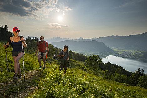 Dreiergruppe wandert mit Aussicht auf den Walchsee